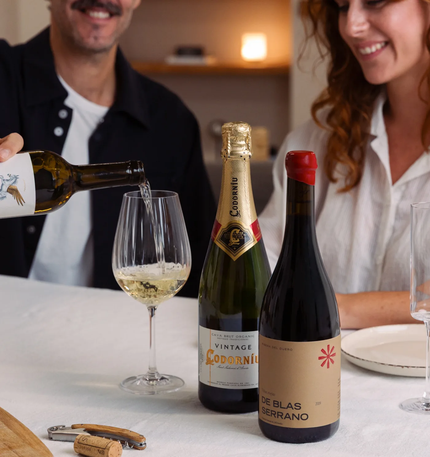 Couple toasting with white wine, cava and red wine at the table