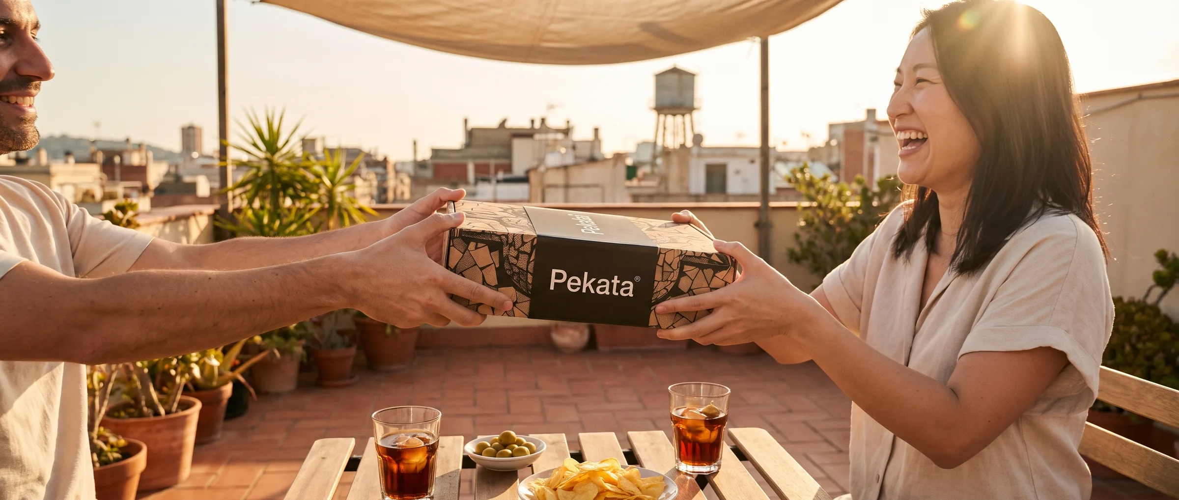 Twee vrienden die een Pekata doos overhandigen op een dak in Barcelona