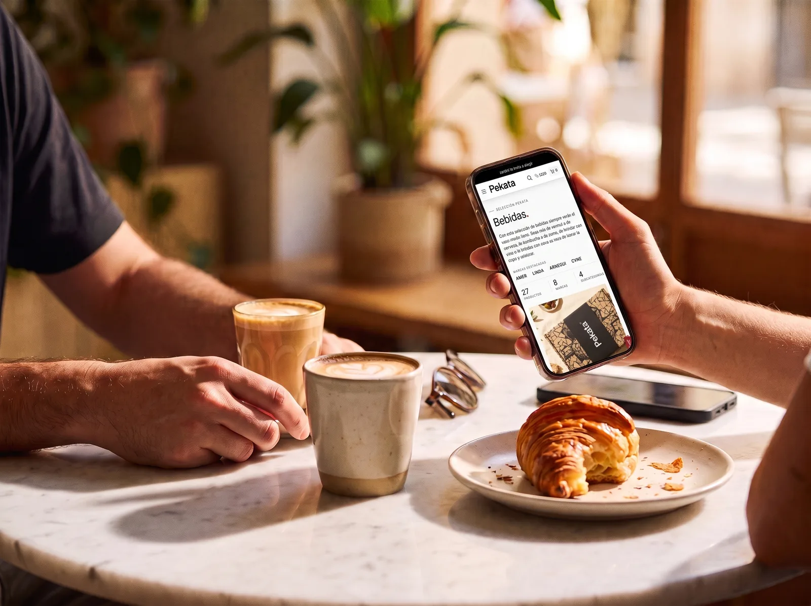 Twee mensen drinken koffie terwijl ze naar het Pekata-portaal op een mobiel kijken